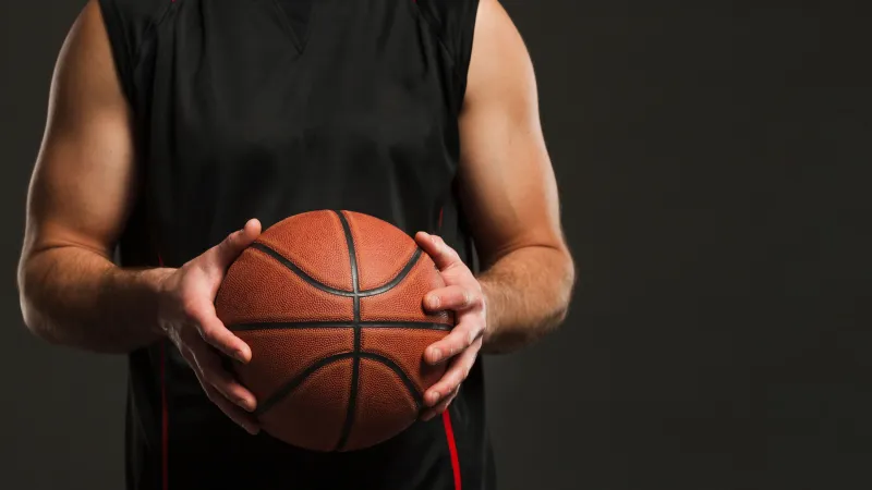 front-view-basketball-held-by-male-player-with-copy-space fot. freepik