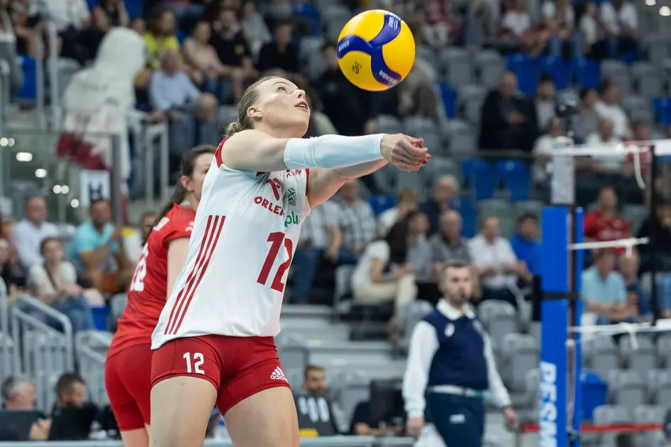 Aleksandra Szczygłowska in a white and red Poland national volleyball team kit bumping a ball during a match