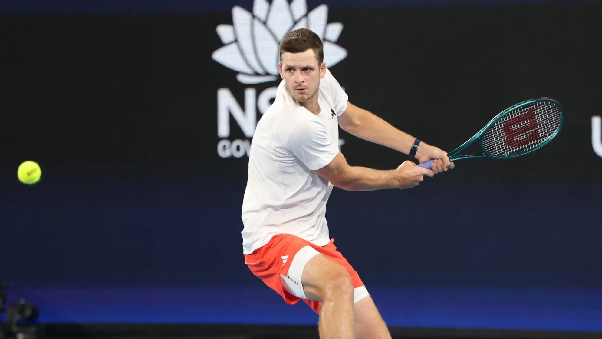 Hubert Hurkacz hitting a two-handed backhand shot during a tennis match