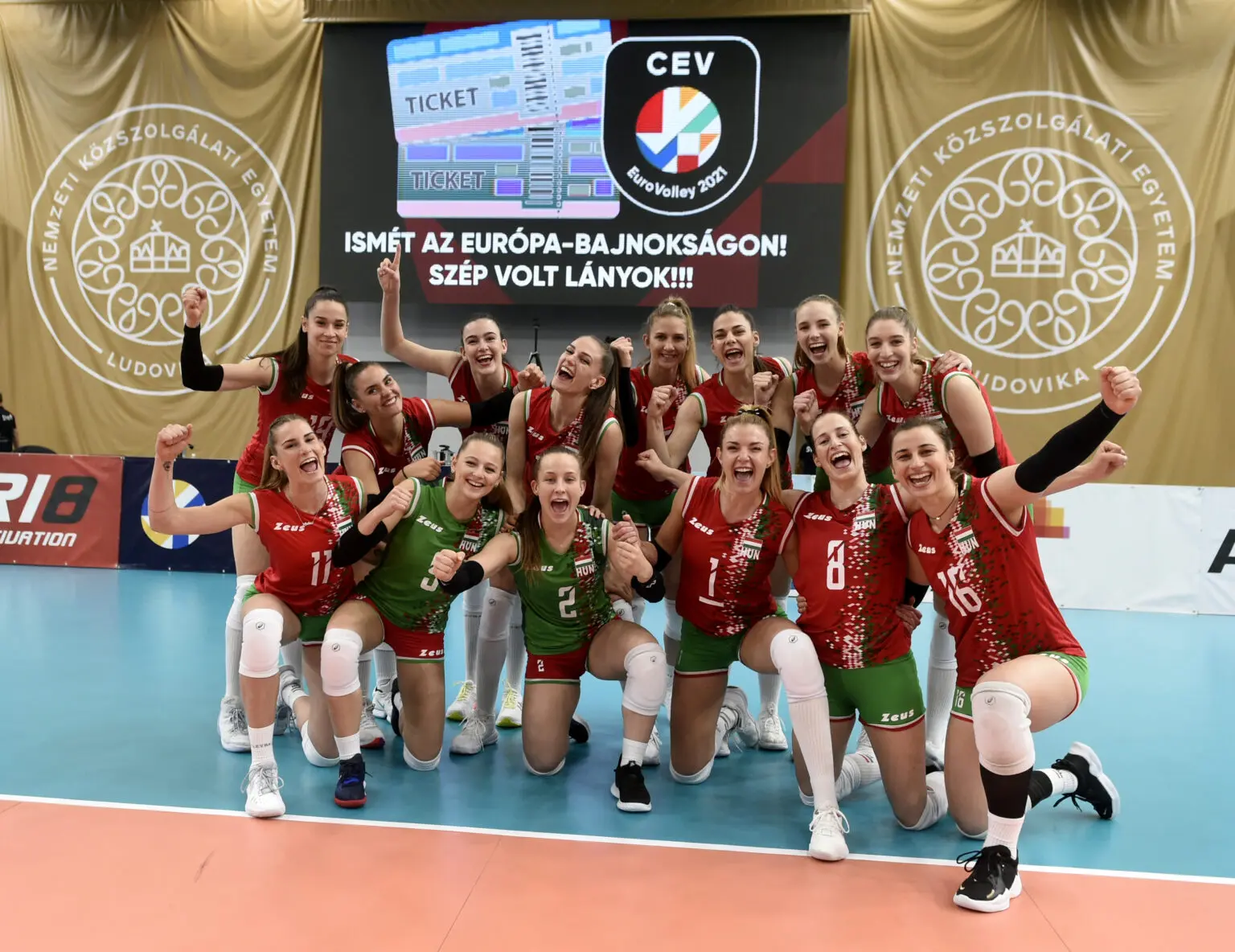 Hungary women's national volleyball team celebrating in red and green uniforms on a court