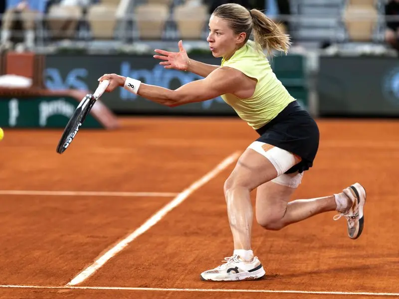 Maja Chwalinska hitting a tennis shot on a red clay court at Roland Garros