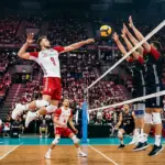 Polish volleyball player attacking at the net in a packed Kraków arena