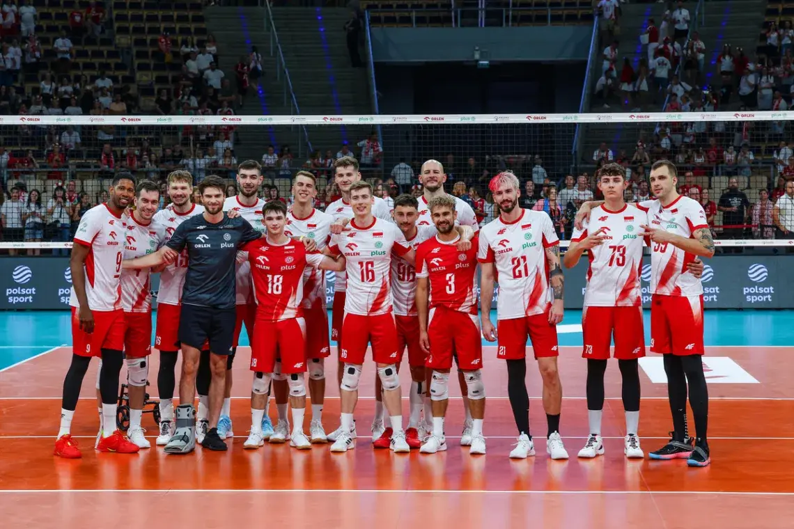 Polish men's national volleyball team posing for a group photo on the court in white and red jerseys