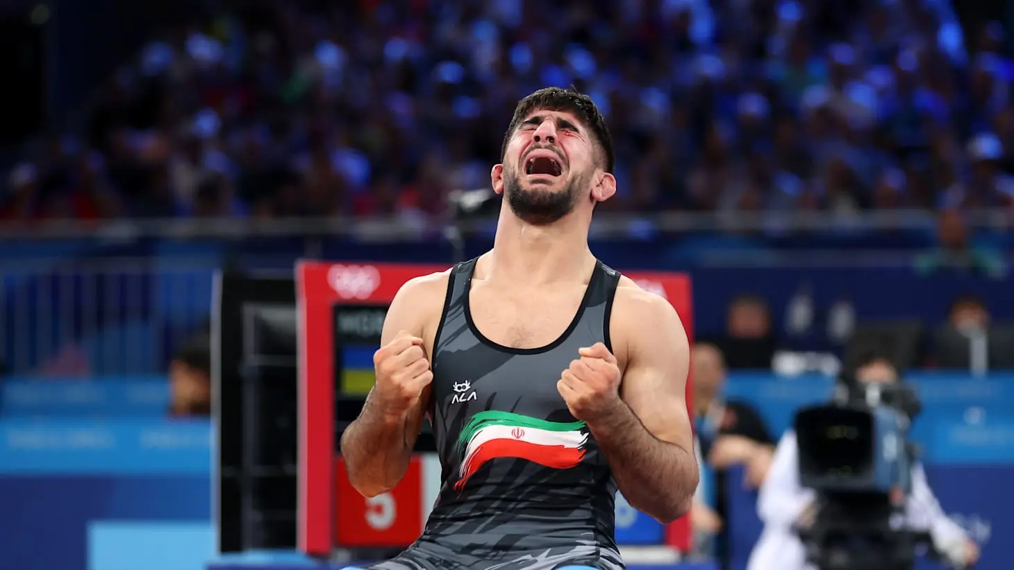 Iranian wrestler Saeid Esmaeili celebrating with clenched fists during a match.