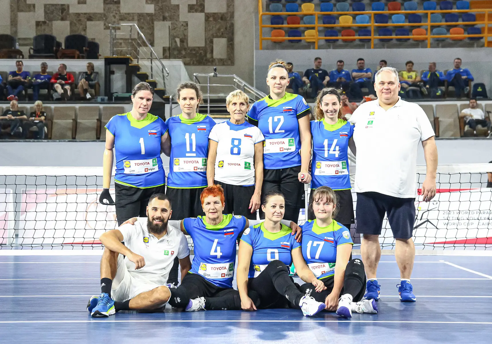 The Slovenia women's national volleyball team posing for a group photo in blue and white uniforms.