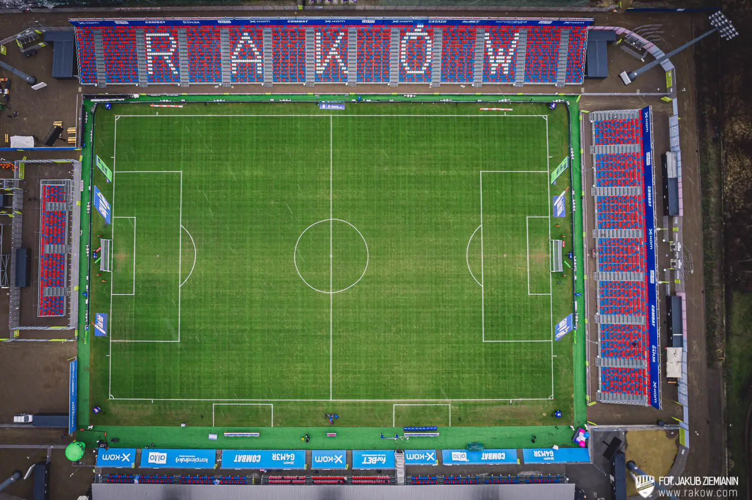Aerial view of the Raków Częstochowa stadium with red and white seats spelling RAKÓW in the main stand