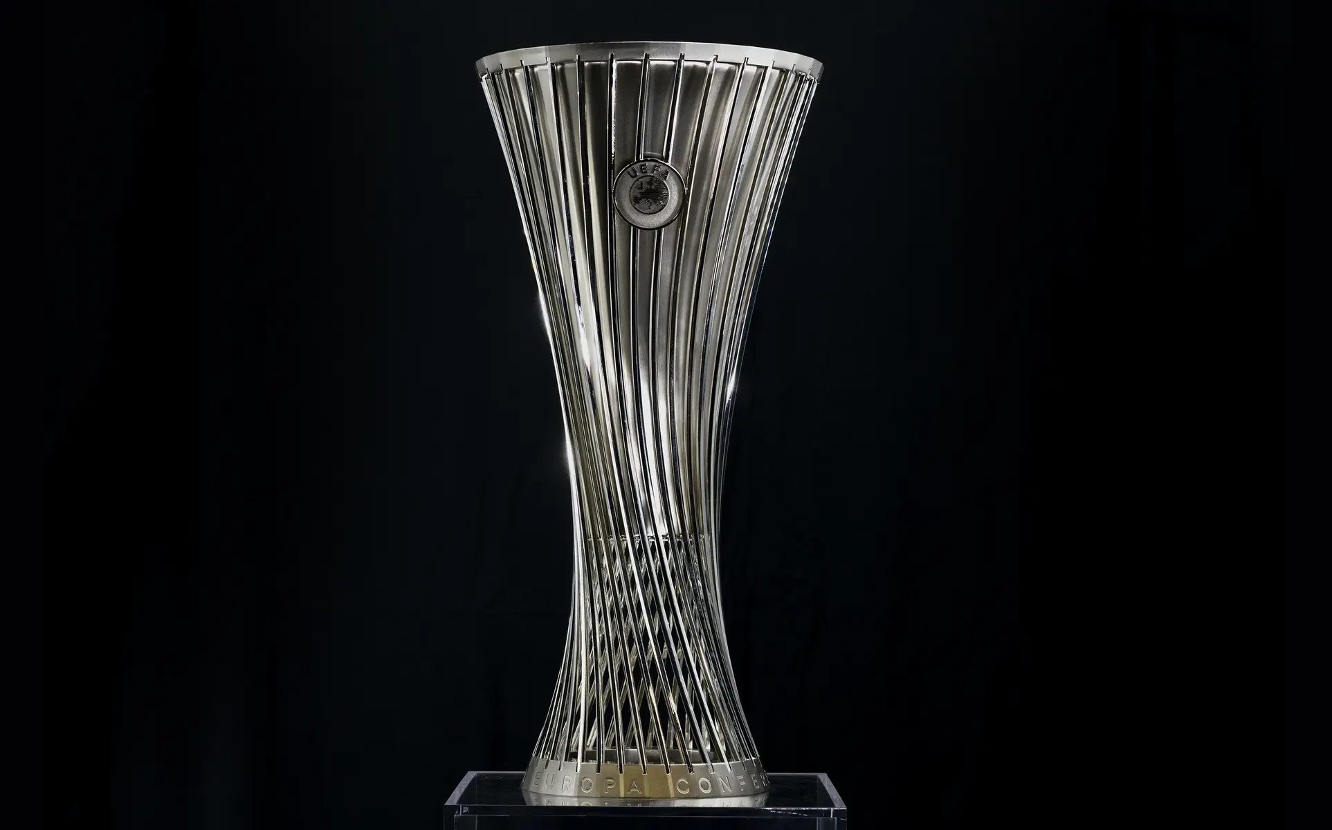 Silver UEFA Europa Conference League trophy against a black background