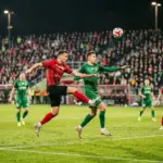 Tense aerial duel between Widzew Łódź and Śląsk Wrocław during a dramatic Ekstraklasa match
