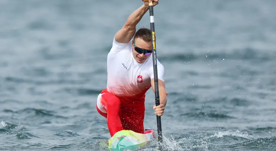 Wiktor Glazunow in a red and white Polish national team outfit paddling a kayak in the water