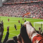 Kibice na stadionie Anfield świętują gola podczas meczu piłki nożnej
