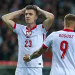 Piłkarze reprezentacji Polski w białych strojach na boisku podczas meczu.