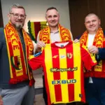 Trzej mężczyźni pozujący z koszulką klubu Korona Kielce