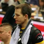 Bartosz Kurek w sportowym stroju z ręcznikiem na ramionach podczas meczu siatkówki.