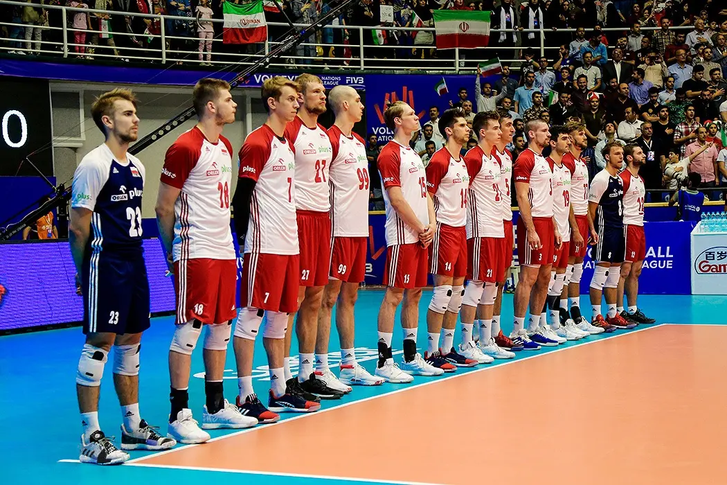 Zawodnicy reprezentacji Polski w siatkówce mężczyzn stojący w rzędzie podczas meczu.