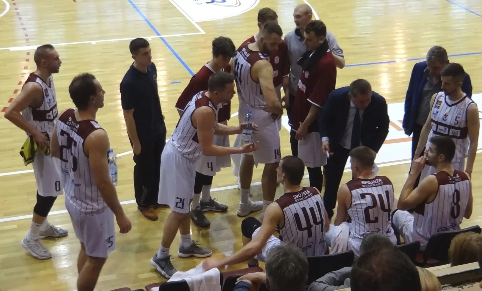 Sebastian Szymański w białym stroju sportowym podczas meczu koszykówki.